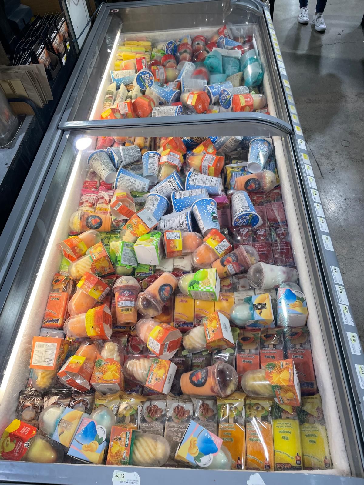 Retail freezer fully stocked with assorted frozen novelties